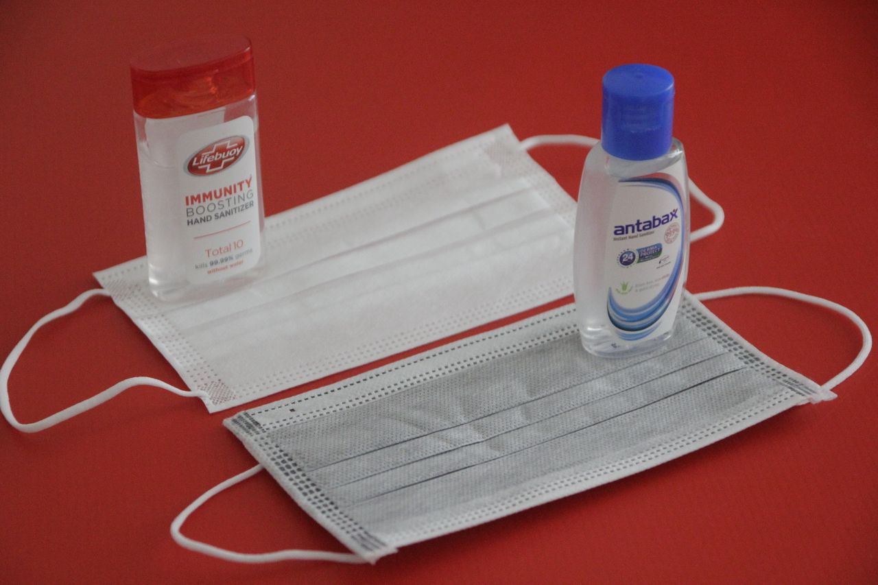 why-choose-us Close-up of face masks and sanitizers on a red surface, emphasizing hygiene.